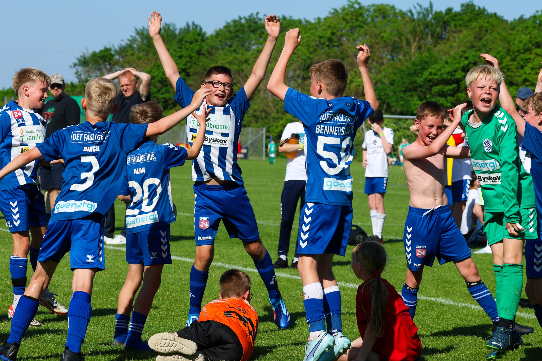 Glade ungdommer i fotballdrakter som jubler